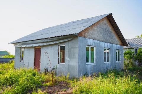 An abandoned unfinished house on a grassy plot. Fotos de archivo