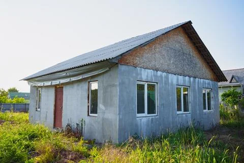 An abandoned unfinished house on a grassy plot. 스톡 사진
