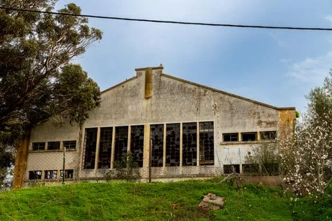 Abandoned Warehouse With Broken Windows Behind Wire Fence 스톡 사진