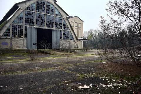 Abandoned warehouse with broken windows in a park on a cloudy day in winter Stock Photos