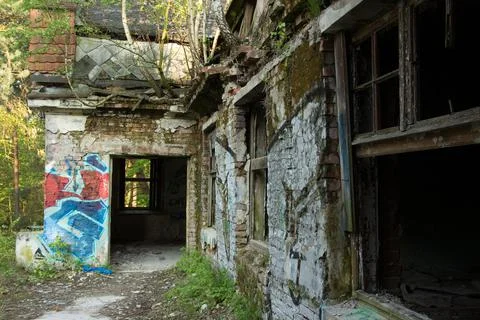 An abandoned, windowless building in the middle of a forest Stock Photos