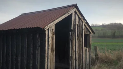 Abandoned wooden cabin with grassy fields in background Stock Footage 169048462