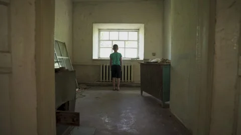 Abandoned young boy in the middle of an old empty house. Stock Footage 314135218
