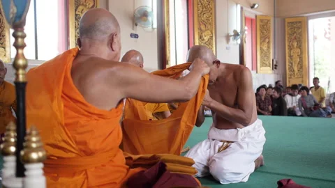 Abbot put robe on a Monk. Ordaining ceremony be a monk in Thai temple Stock Footage 161786078