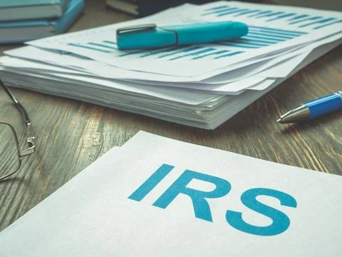 Abbreviation IRS and stack of financial papers. Stock Photos