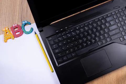 ABC programming language. Laptop on wooden table background. Alphabet on white Stock Photos