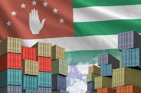 Abkhazia flag and big stack of shipping cargo containers in docks with sky Foto stock