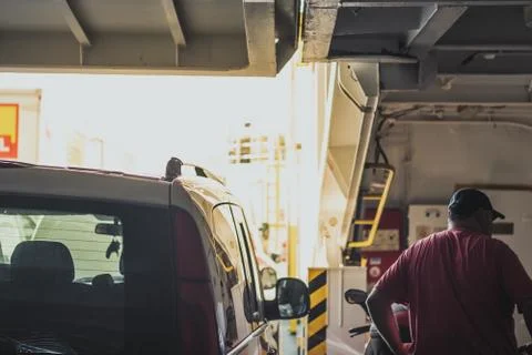 Aboard a car ferry standing between the cars, view of the front ramp and sun  Stock Photos