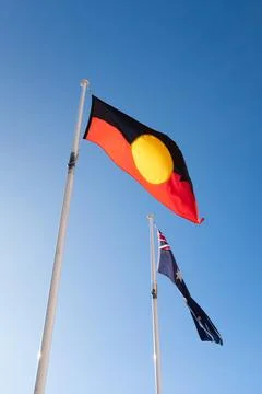 An aboriginal First Nations indigenous flag flying in front of an Australian Stock Photos