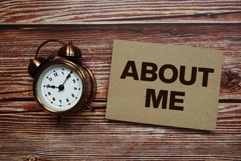 About Me text with alarm clock on wooden background Stock Photos