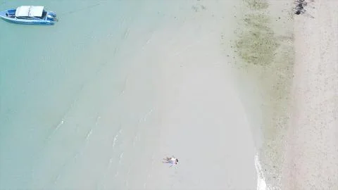 Above angle of happy wedding couple is lying on a tropical sandy beach near the Fotos Stock