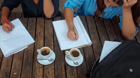 Above angle view of casual entrepreneur woman team/student team, writing down th Stockbeeldmateriaal 199633334