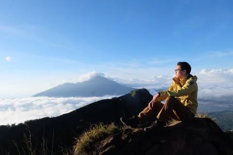 Above Cloud Nine, Mount Batur's Peak, Asian Man Trekker  and Cloud Sea Stock Photos
