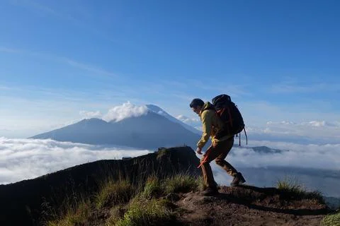 Above Cloud Nine, Mount Batur's Peak, Asian Man Trekker  and Cloud Sea Stock Photos