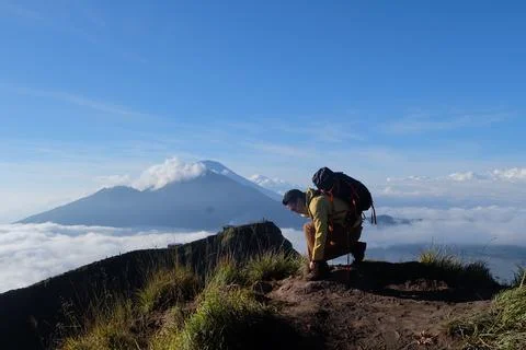 Above Cloud Nine, Mount Batur's Peak, Asian Man Trekker  and Cloud Sea Stock Photos