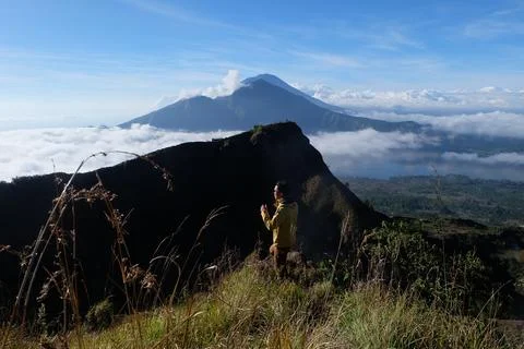 Above Cloud Nine, Mount Batur's Peak, Asian Man Trekker  and Cloud Sea Stock Photos