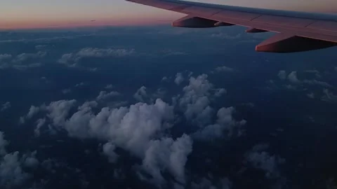 Above clouds view from a plane, airplane window view, sunset Stock Footage 280499323