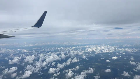 Above the Clouds View Through Airplane Window. Wide Blue Wing Cloudy Day Stock Footage 319593062