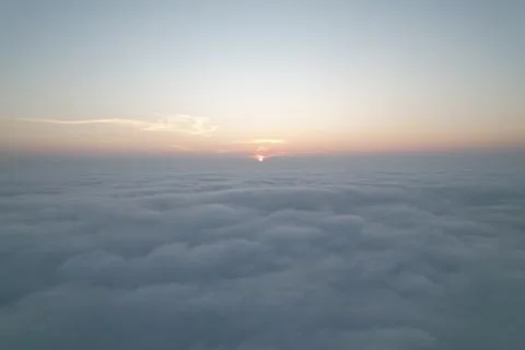 Above the Cloudscape: Sunrise Breaking Through Dense Cloud Cover - An Aeria.. Foto stock