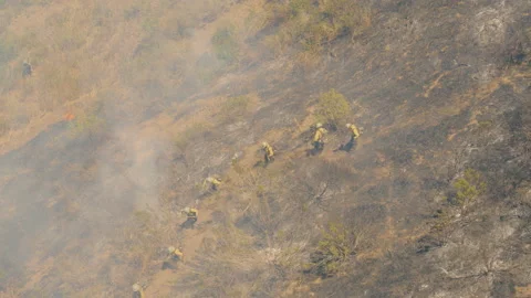From Above Drone View of Firefighters make their way down a steep side of a hill Stock Footage 199161840