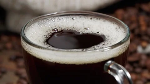 From above drop falling into cup of freshly brewed coffee with bubbles on table Stock Footage 146869320