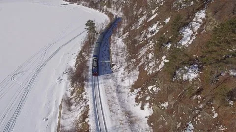 From above epic passenger train on winter Circum-Baikal railway expedition lake Stock Footage 317963693