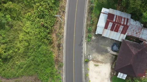 Above eye view of a small two lane road with a yellow line in the middle Stock Footage 142761574