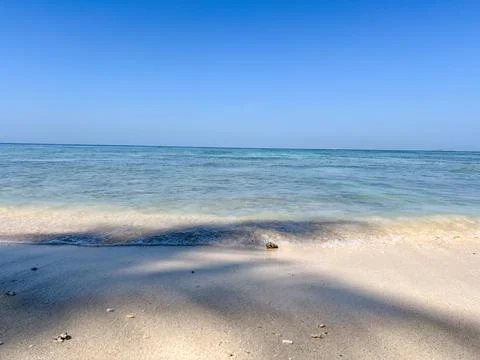 Above gentle waves lapping in pristine clear bay of water Stock Photos