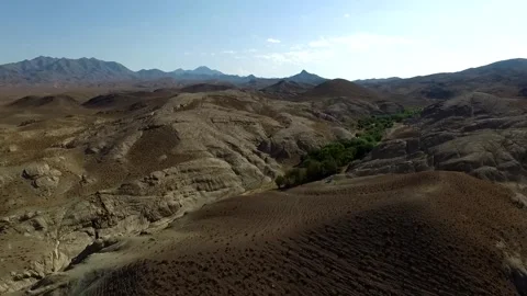 From above a green landscape rests between rugged valleys, stock footage. Stock Footage 304783777