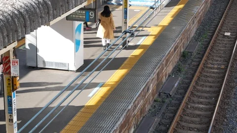 From above to japan's train station in winter daytime while train is leaving Stock Footage 122684833