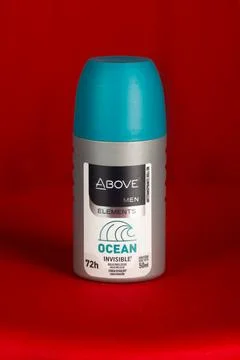 Above men elements ocean brand deodorant, standing against a red background. Stock Photos