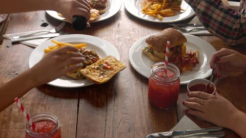 Above panning view of a young multicultural group of friends, sharing a meal/eat Stock Footage 199633557