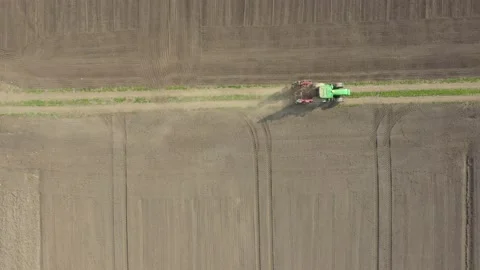 Above parallel dolly move view, shot of tractor traveling with seed cultivator Stock-Footage 167156459