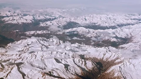 Above the peaks a clouds covers the sky, snow capped Alps rugged mountain peaks. Stock Footage 314850825