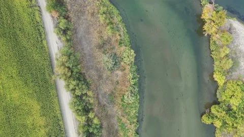 Above the Snake River looking down at the blue water and green farm fields Stock Footage 165471403