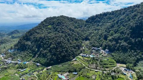 From above, terraced fields and hot spring pools sit at the base of towering Stock Photos