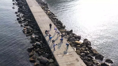 Above top view children training outdoors on the pier by the sea aerial 4K Stock Footage 119263844