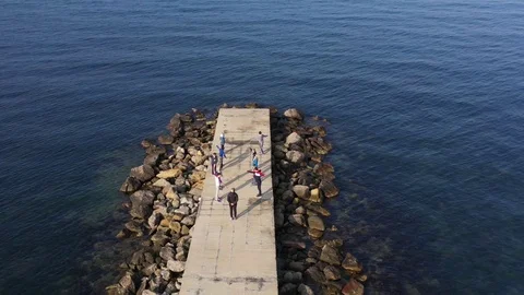 Above top view children training outdoors on the pier by the sea aerial 4K Stock Footage 119263849