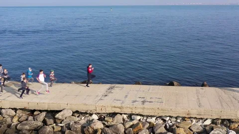 Above top view children training outdoors on the pier by the sea aerial 4K Stock Footage 119263864