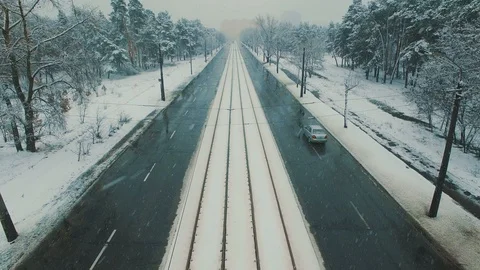 Above top view on winter forest road with cars and tram at snowfall Stock Footage 86156312
