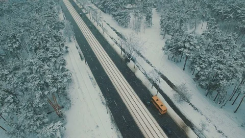 Above top view on winter forest road with cars and tram at snowfall Stock Footage 86156632