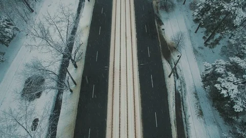 Above top view on winter forest road with cars and tram at snowfall Stock Footage 86157202