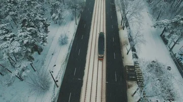 Above top view on winter forest road with cars and tram at snowfall Stock Footage 86157436