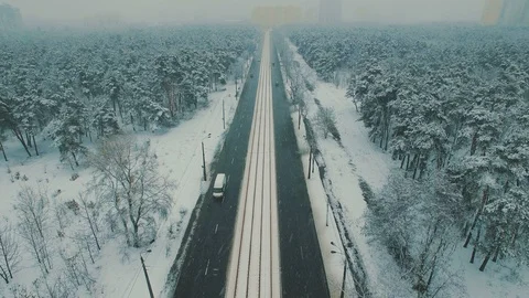 Above top view on winter forest road with cars and tram at snowfall Stock Footage 86157679