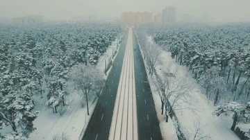 Above top view on winter forest road with cars and tram at snowfall Stock Footage 86157838