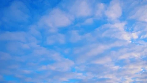Above a tranquil landscape, fluffy clouds drift across sky Stock Footage 331463044