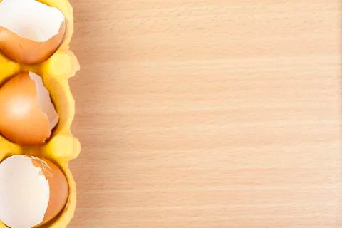 Above view of broken egg shells in a yellow egg carton Foto stock