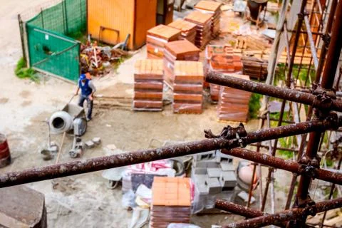 Above view on building site, worker is pushing industrial tipping wheelbarrow Stock Photos