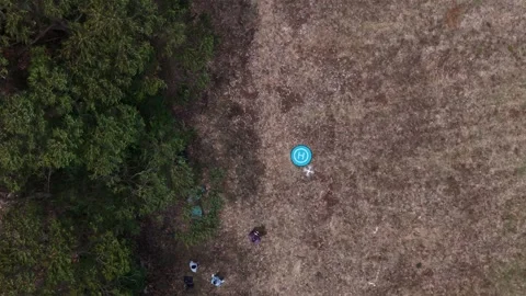 Above view capturing a drone landing on a pad on a field Stock Footage 311589444