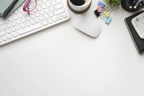 Above view coffee cup, notebook and calculator on white office desk. Copy spa Foto stock